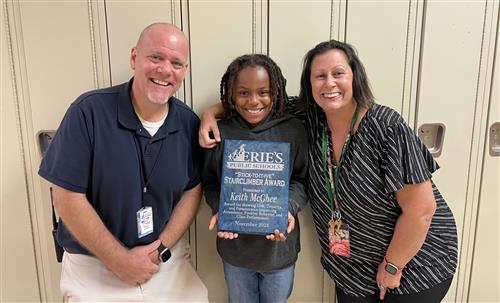 Keith McGhee, Harding's November Stairclimber, poses with his plaque and school staff.